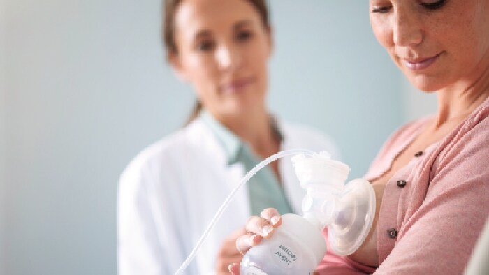 eine Frau, die eine Milchpumpe hält