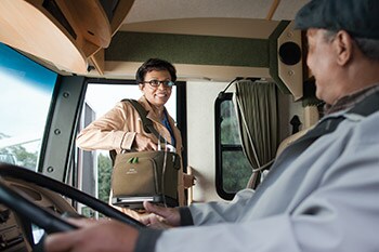 Eine Frau steigt mit einem SimplyGo tragbaren Sauerstoffkonzentrator in einen Bus ein