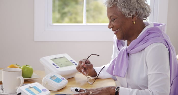 Lady sat at desk using a pulse oximeter