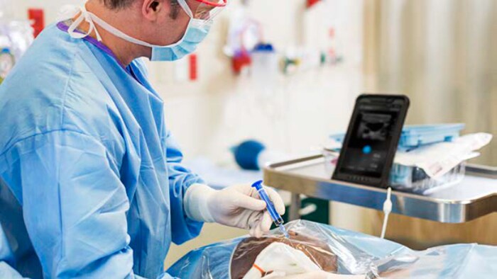 Medizinische Fachkraft beim Einsatz des Handheld-Ultraschallgeräts und Beobachten der Ergebnisse