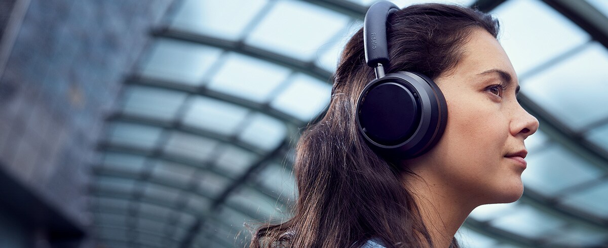 Frau trägt am Strand Philips True Wireless Sportkopfhörer