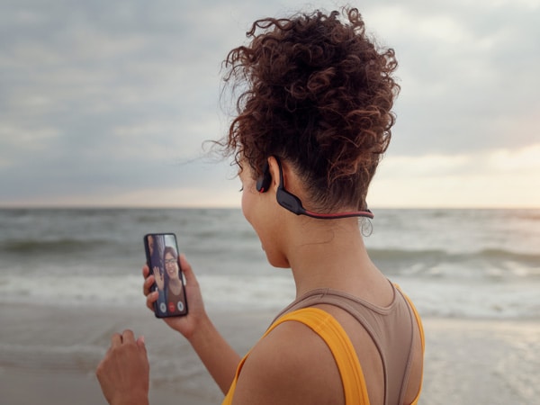 Frau genießt die kristallklare Anruffunktion der Philips Kopfhörer mit Knochenschall-Übertragung