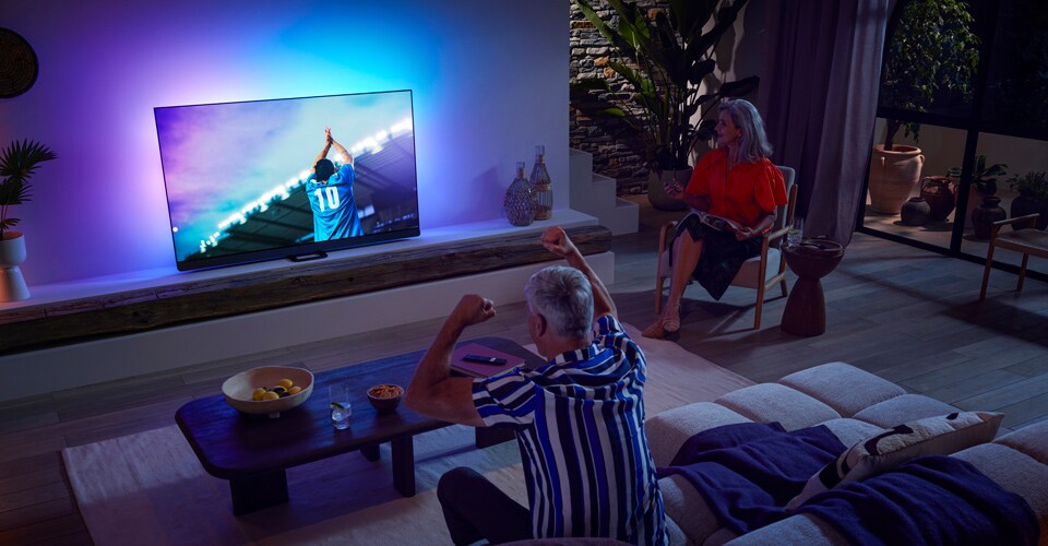 Eine Familie schaut eine Sportübertragung auf einem OLED-TV
