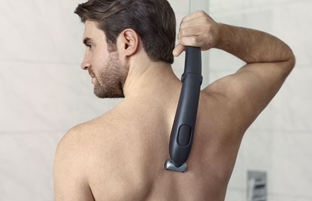 Ein Mann rasiert seinen Rücken mit einem Philips Bodygroomer mit extra langem Griff.