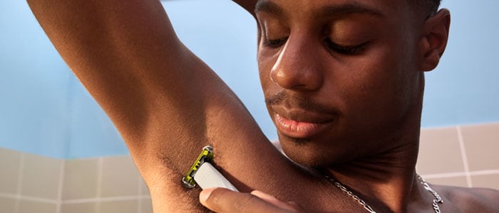 Close up photograph of a man shaving under his arm with a Philips OneBlade